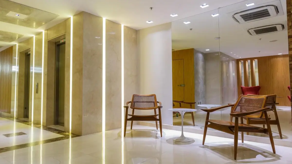 Hall de entrada do Hotel Atlântico Travel Copacabana, com mármore e elevadores