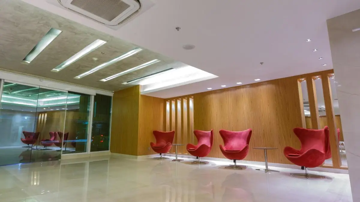 Sala de estar do lobby do Hotel Atlântico Travel Copacabana, com poltronas vermelhas